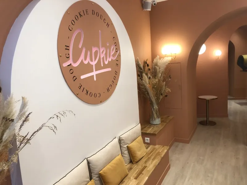 L’intérieur de la boutique Cupkie : banquette, macaron Cupkie au mur, murs terracotta