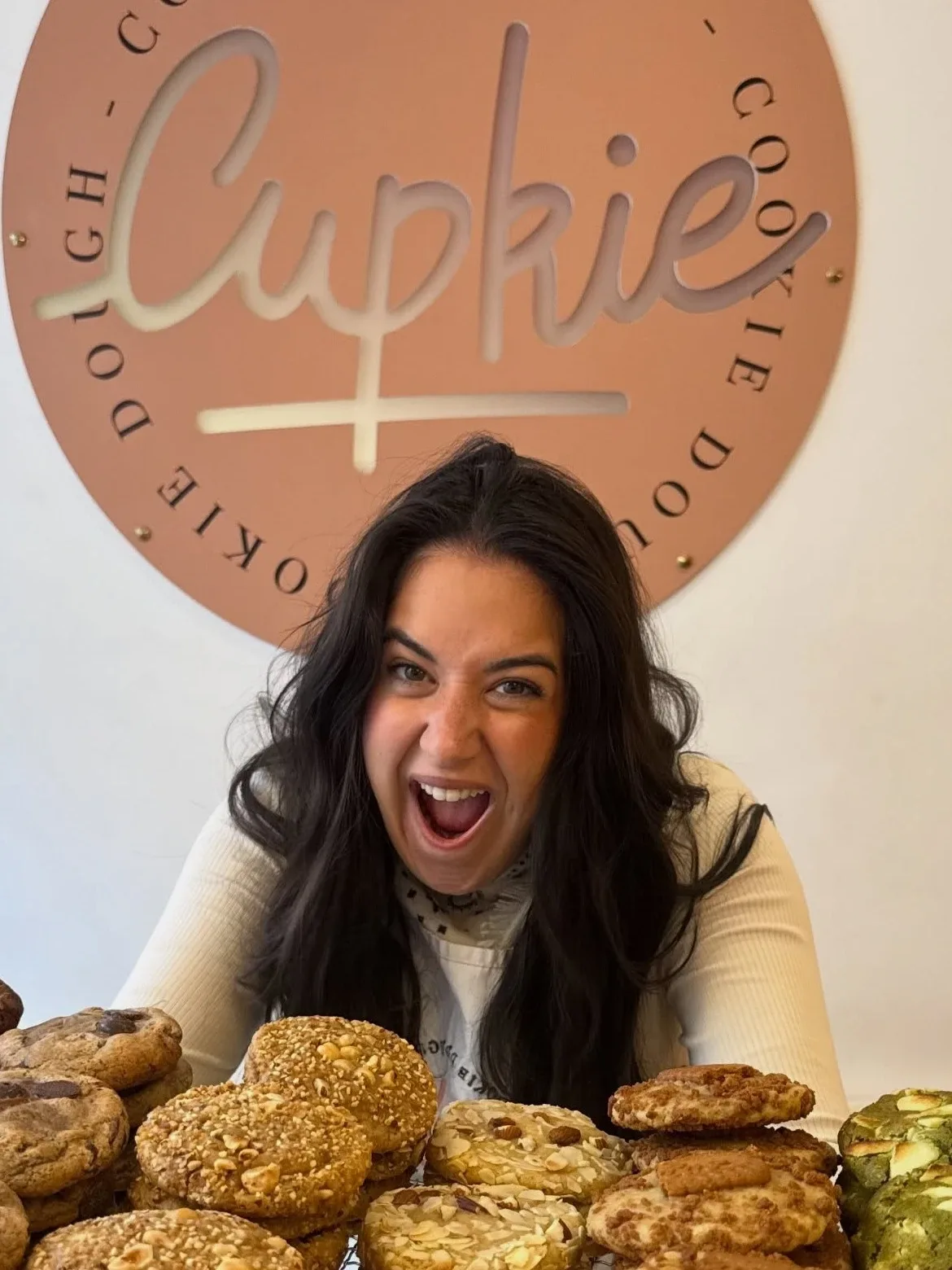 Portrait de Megan Villiot, fondatrice de Cupkie, devant le logo de la boutique